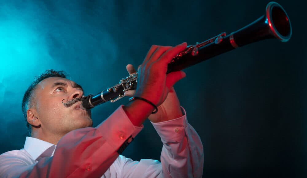 Musician playing clarinet on stage.